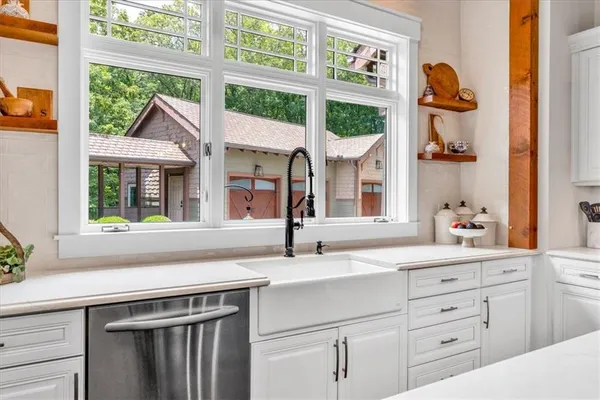 a dining room with wooden floor a chandelier a glass table and chairs