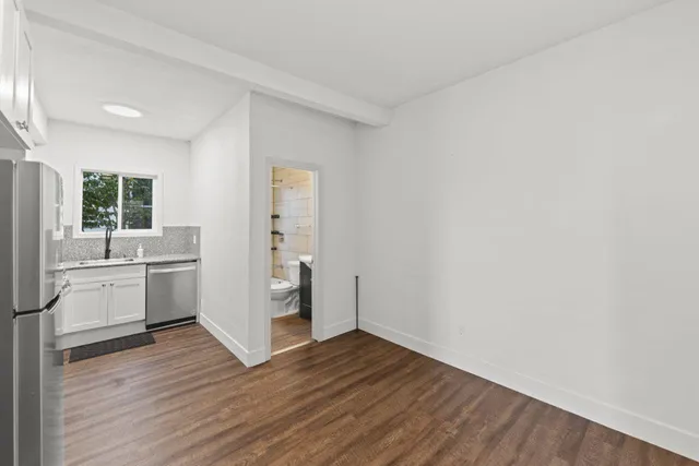 a view of a kitchen with wooden floor and a sink