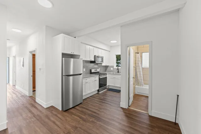 a kitchen with white cabinets and stainless steel appliances