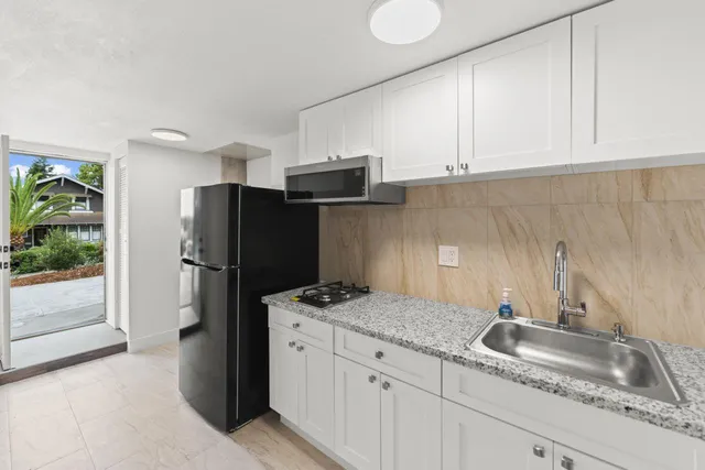 a kitchen with stainless steel appliances granite countertop a refrigerator and a sink