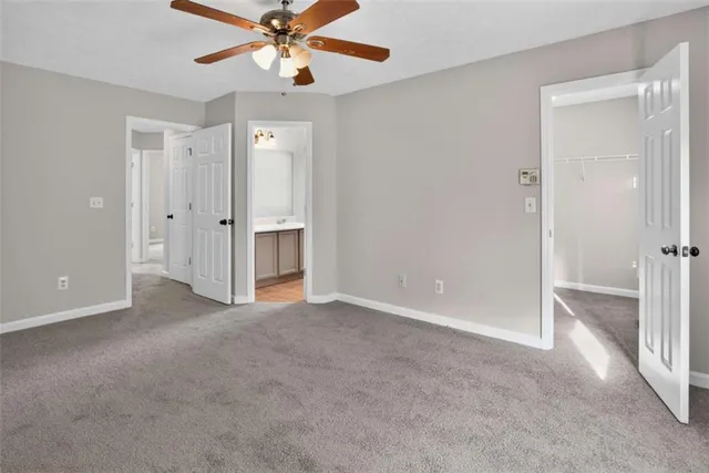 an empty room with closet and a ceiling fan
