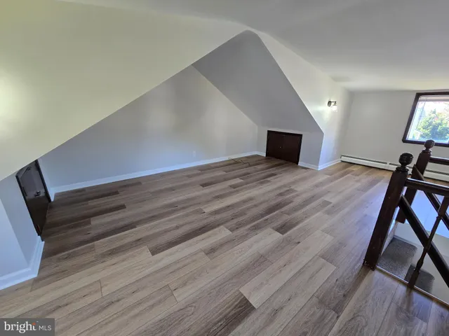 a room with a bed and wooden floor