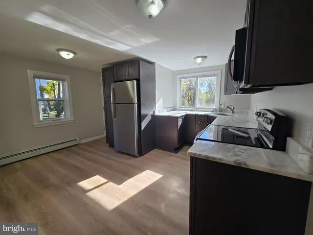 a kitchen with stainless steel appliances granite countertop a sink refrigerator stove and microwave