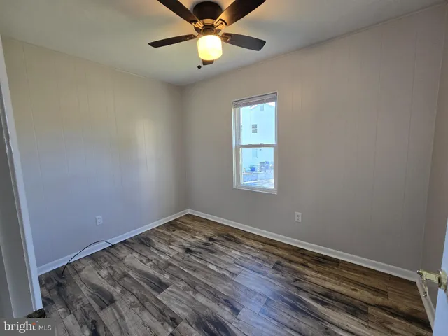 an empty room with a window and ceiling fan