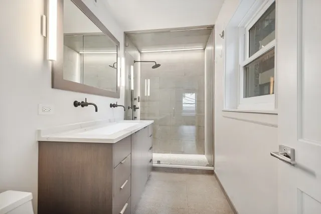 a bathroom with a sink a mirror and a shower
