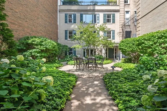 a front view of a house with a garden and outdoor seating