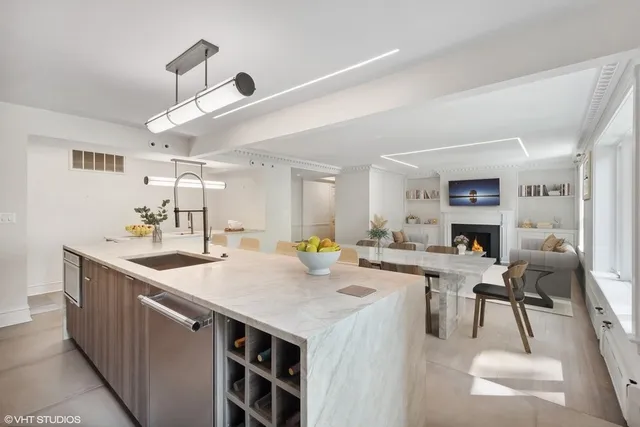 a kitchen with a counter top space a sink appliances and cabinets