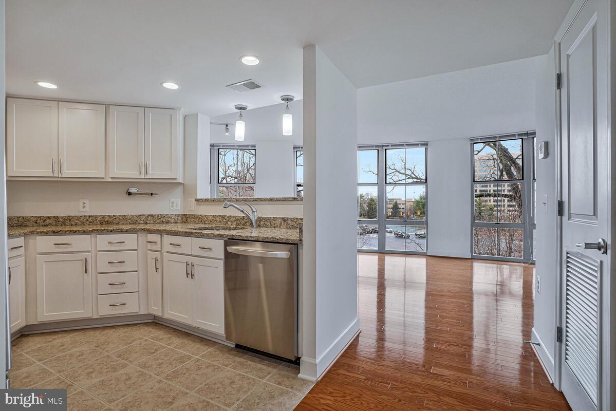 11800 Sunset Hills Road, Unit 514 Reston, VA 20190 - Photo 29 of 57 a kitchen with granite countertop a stove top oven sink and cabinets