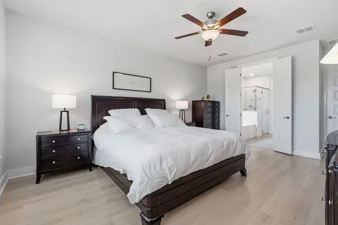 a spacious bedroom with a bed and a chandelier