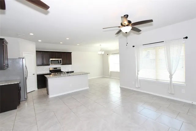 a large kitchen with a large counter top appliances and cabinets