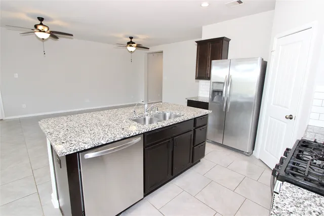 a kitchen with stainless steel appliances granite countertop a refrigerator a sink and dishwasher