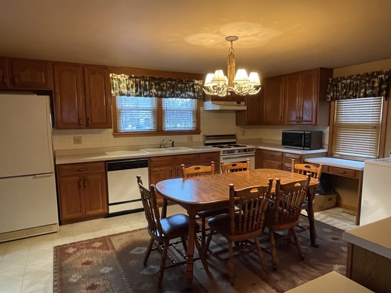 210 South Main Street Herscher, IL 60941 - Photo 6 of 23 a kitchen with stainless steel appliances granite countertop a dining table chairs and a refrigerator