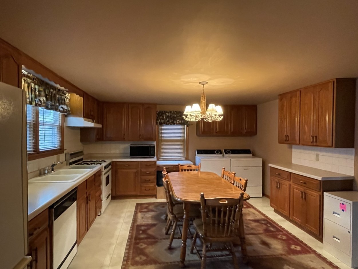 210 South Main Street Herscher, IL 60941 - Photo 8 of 23 a kitchen with a table chairs stove and cabinets