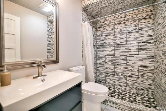 a bathroom with a sink a toilet and mirror