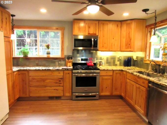 150 Southeast Palmblad Drive Gresham, OR 97080 - Photo 17 of 36 a kitchen with granite countertop a stove and a sink