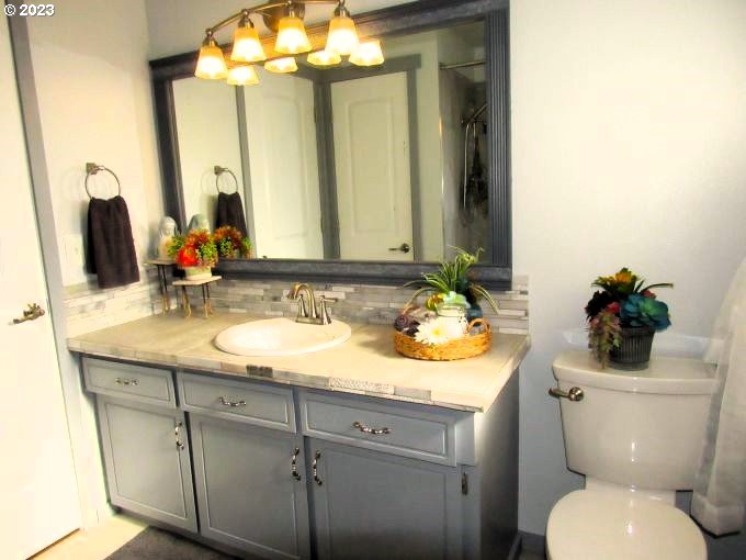 150 Southeast Palmblad Drive Gresham, OR 97080 - Photo 27 of 36 a bathroom with a granite countertop toilet sink and mirror