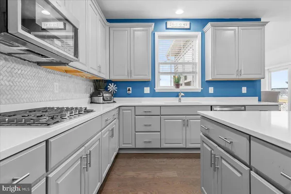 a kitchen with cabinets appliances a sink and a window