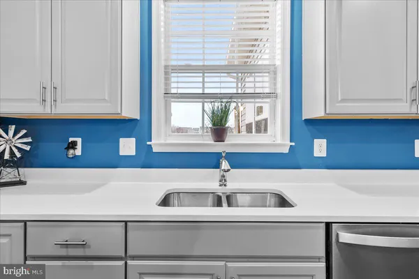 a kitchen with stainless steel appliances granite countertop a sink and dishwasher a stove top oven with white cabinets