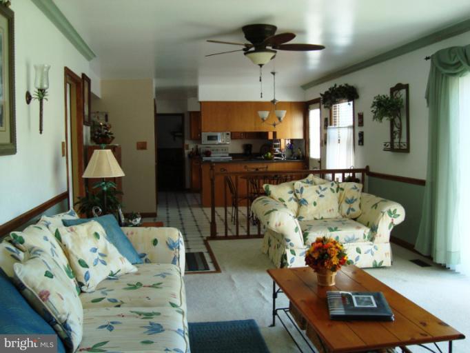8166 N Road Severn, MD 21144 - Photo 2 of 25 a living room with furniture and a chandelier
