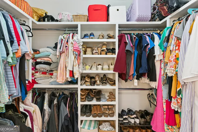 a view of walk in closet with clothes and shoes