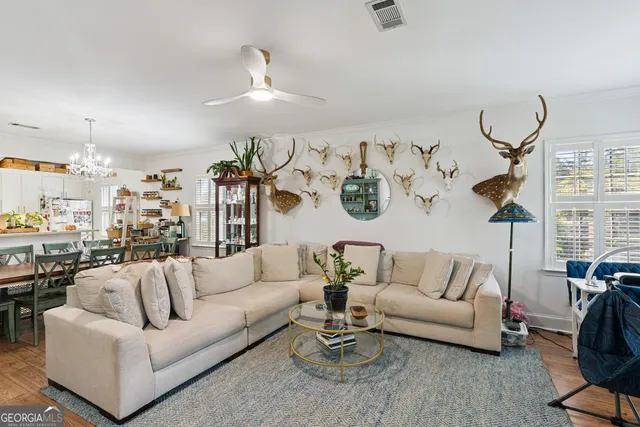 a living room with furniture kitchen view and a large window