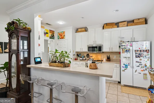 a view of a kitchen with fridge and workspace
