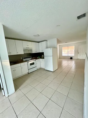 a kitchen with stainless steel appliances a stove a microwave a sink a refrigerator and cabinets