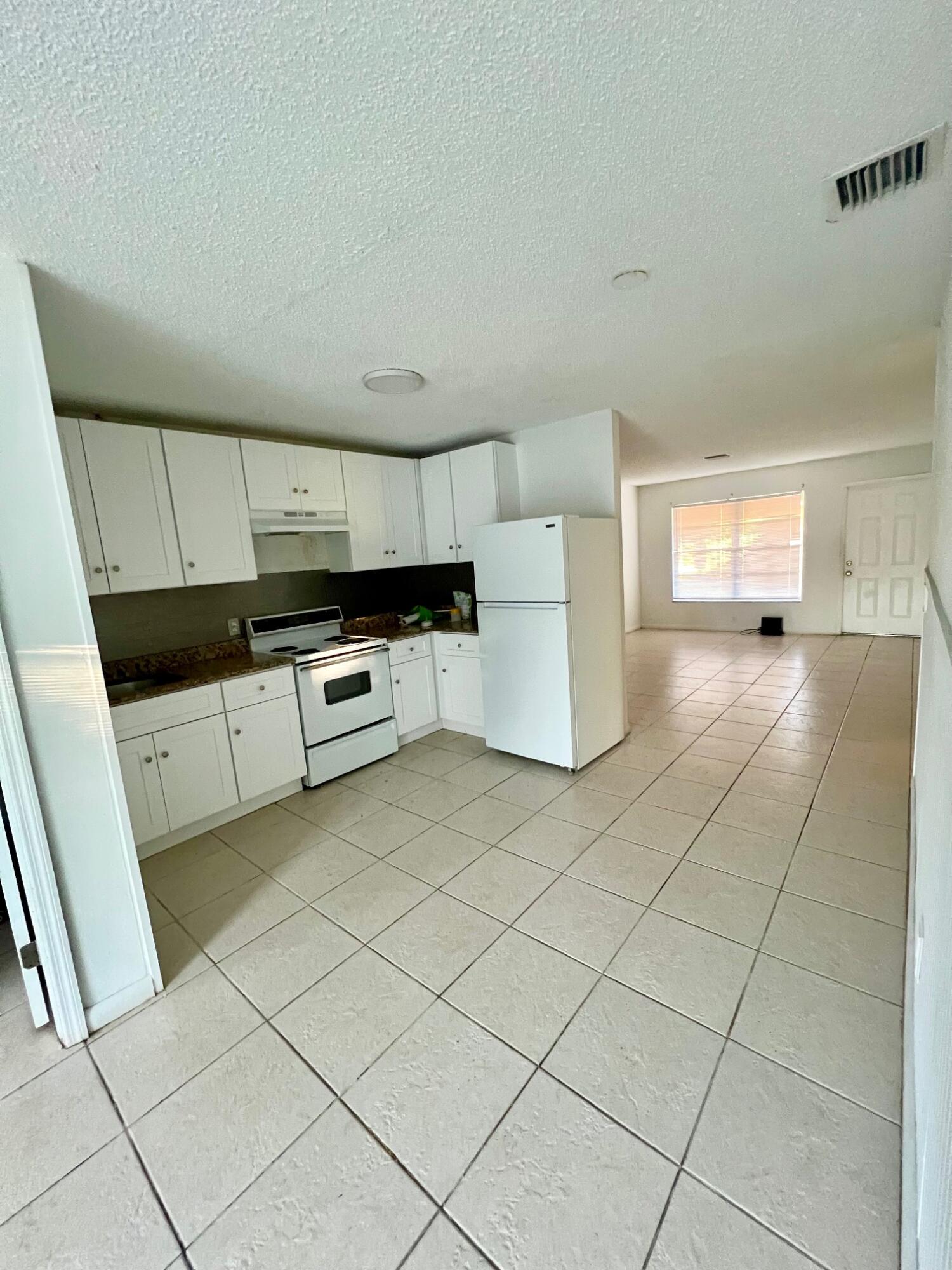 3300 Southeast Fairmont Street Stuart, FL 34997 - Photo 4 of 13 a kitchen with stainless steel appliances a stove a microwave a sink a refrigerator and cabinets