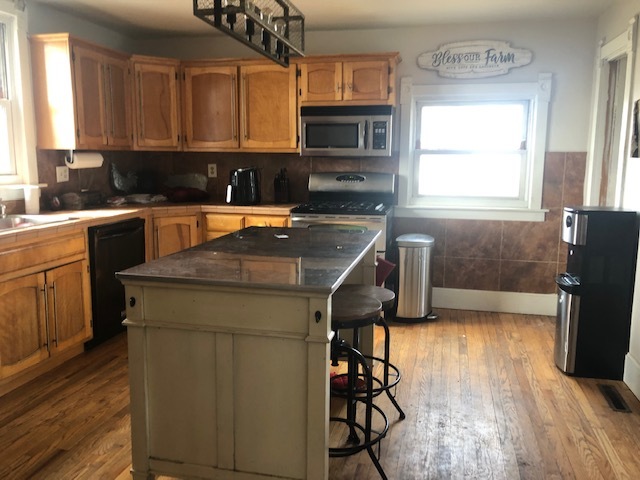 28240 South Walsh Road Manhattan, IL 60442 - Photo 8 of 26 a kitchen with granite countertop a stove a sink and a microwave