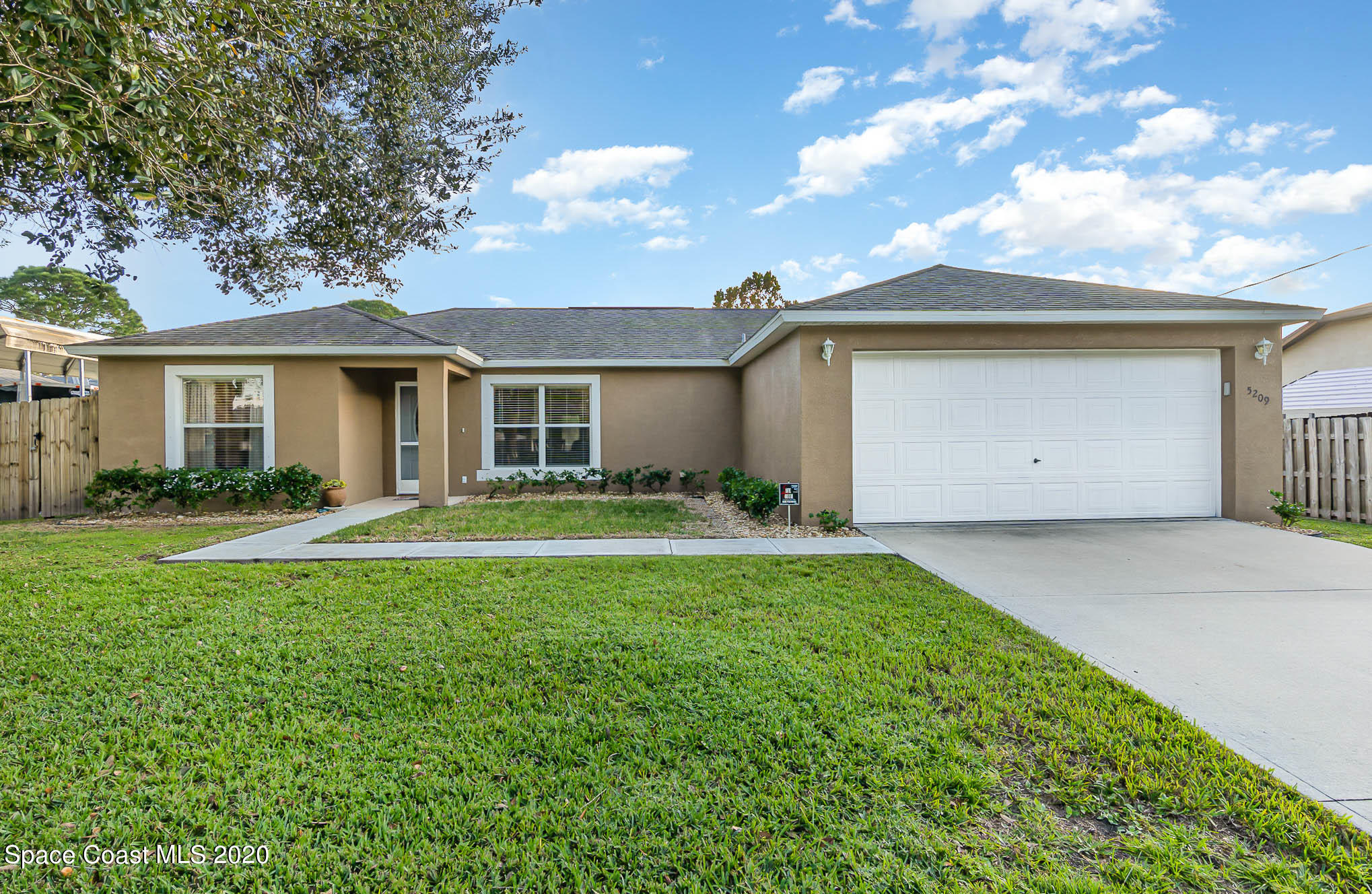 5209 Carrick Road Cocoa, FL 32927 - Photo 1 of 23 a front view of a house with a garden and yard