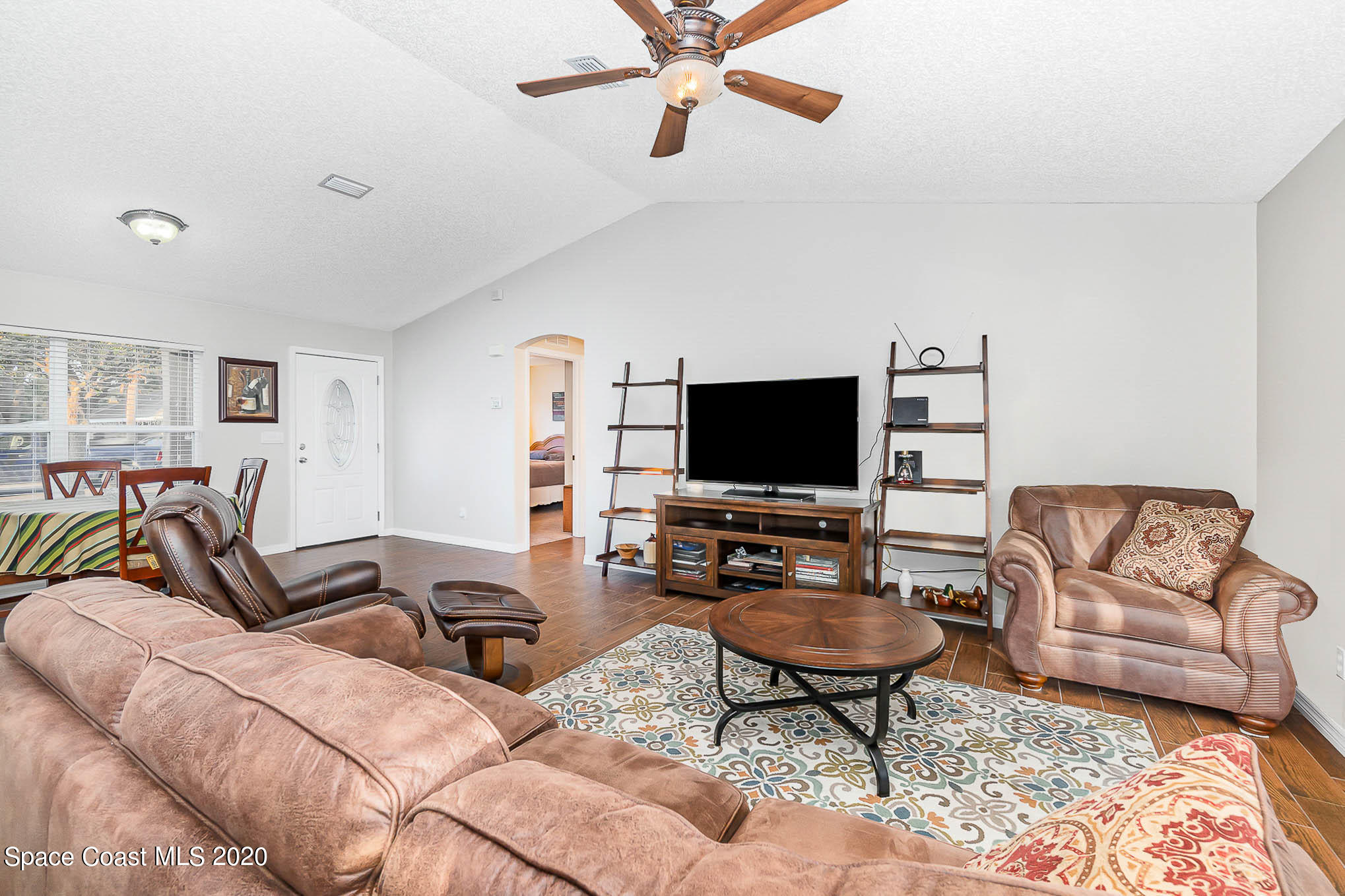 5209 Carrick Road Cocoa, FL 32927 - Photo 5 of 23 a living room with furniture a flat screen tv and a window