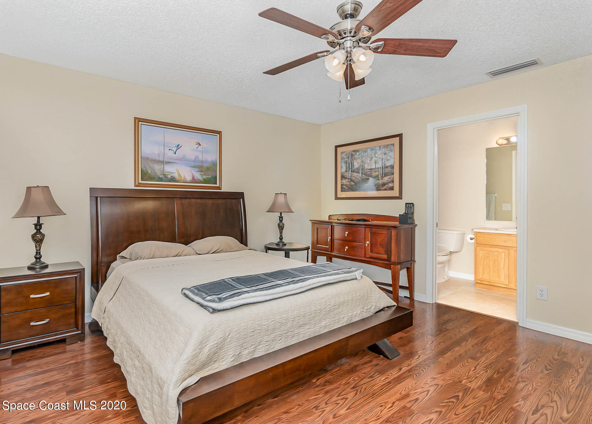 5209 Carrick Road Cocoa, FL 32927 - Photo 10 of 23 a bedroom with a large bed and a chandelier