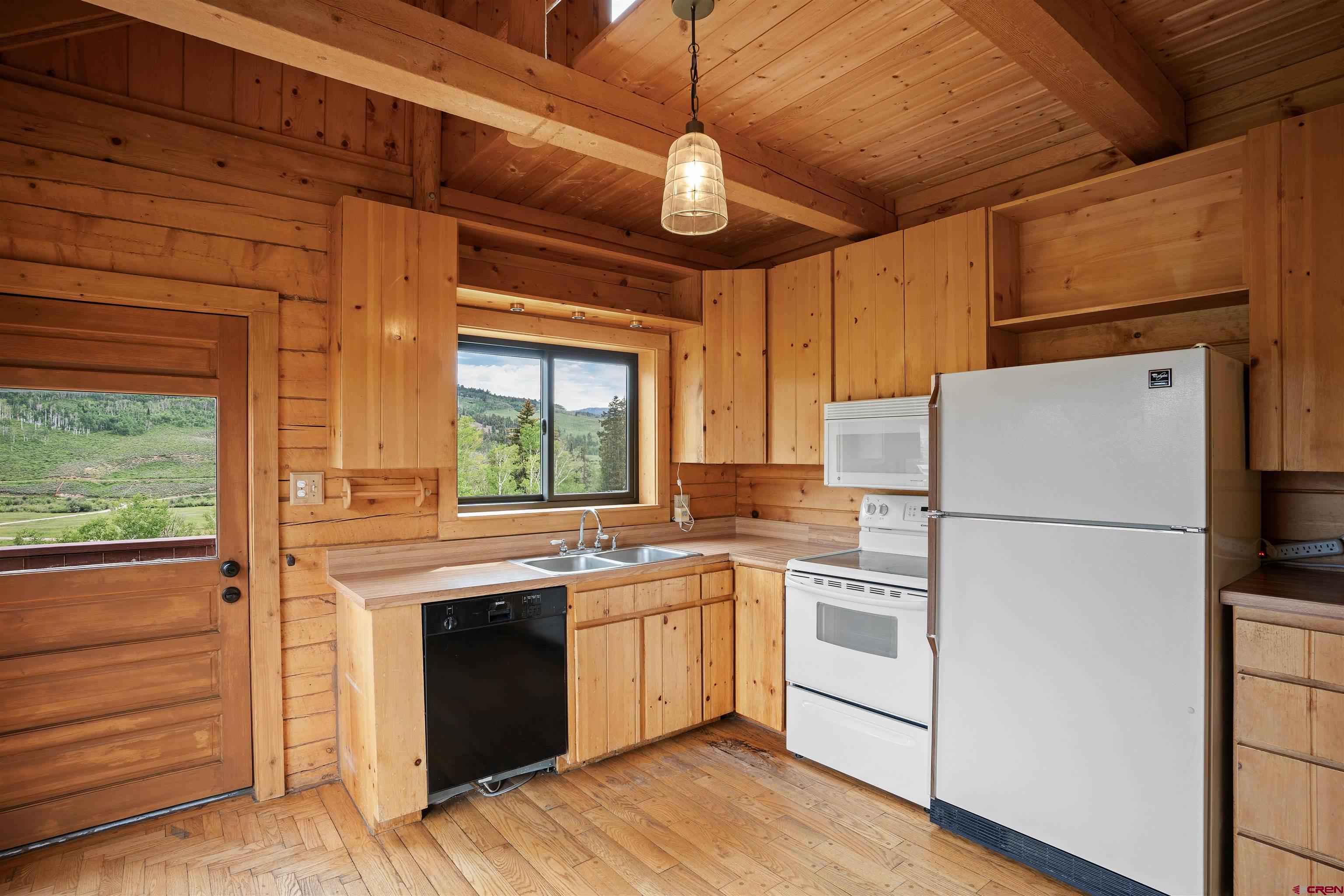 320 Sioux Road Gunnison, CO 81230 - Photo 8 of 35 a kitchen with a stove a sink and a refrigerator