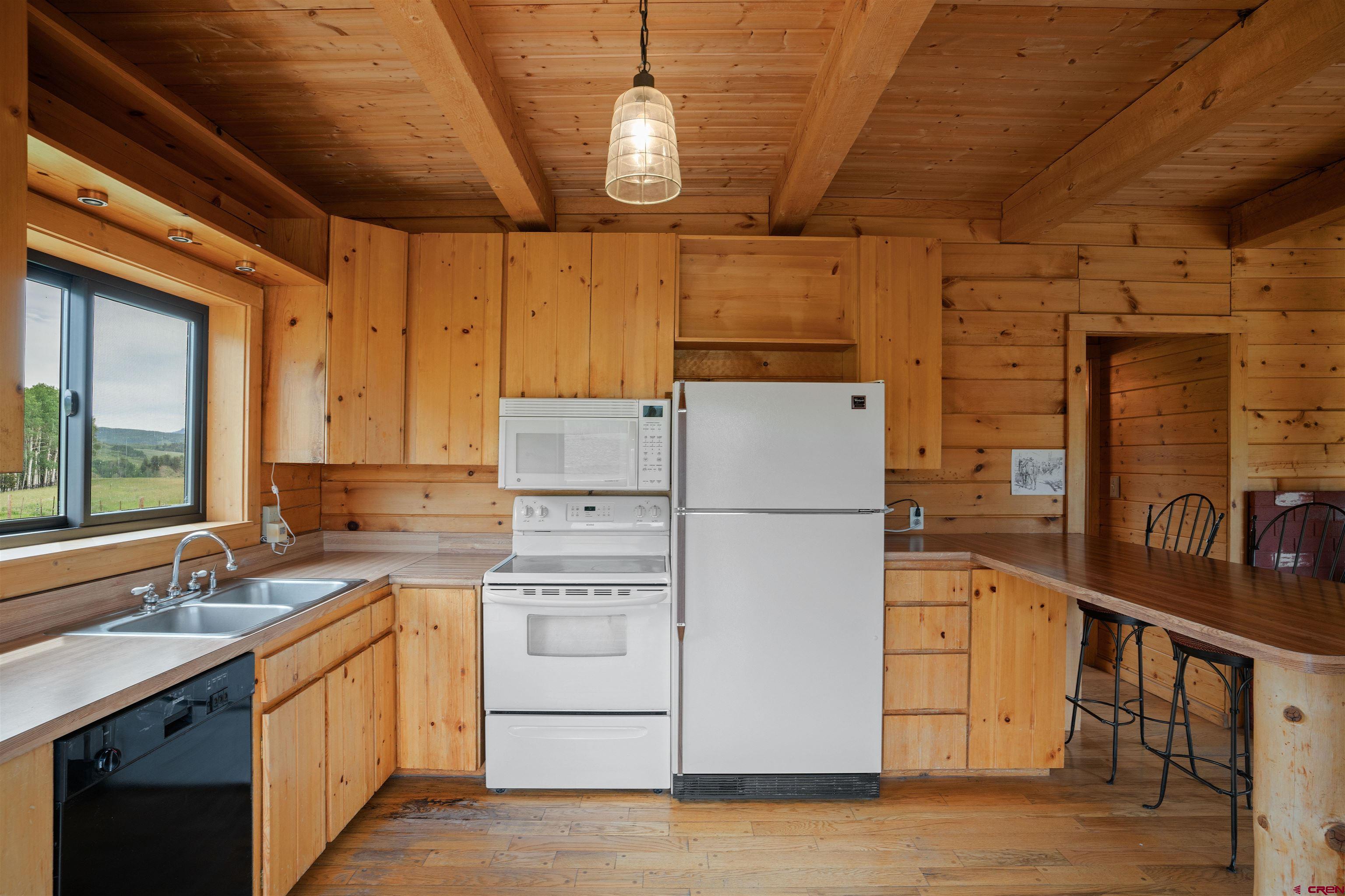 320 Sioux Road Gunnison, CO 81230 - Photo 9 of 35 a kitchen that has a lot of white cabinets and wooden floor