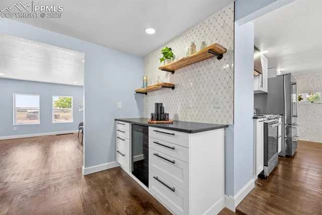 a kitchen with cabinets wooden floor and stainless steel appliances
