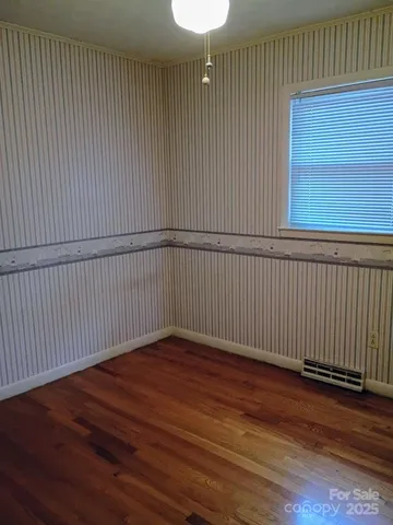 an empty room with wooden floor and closet