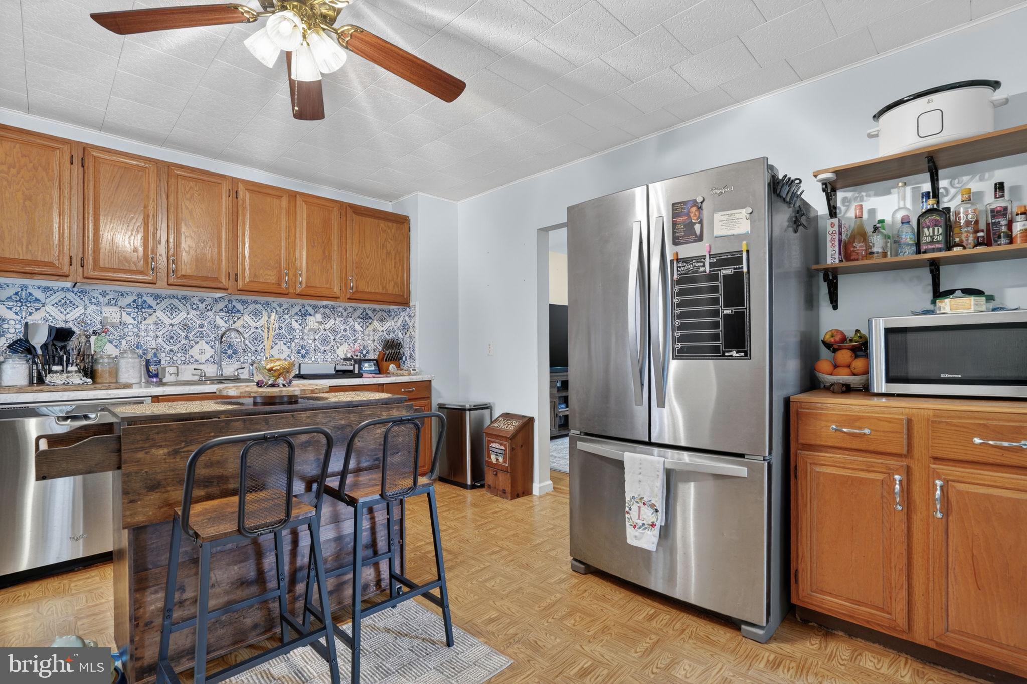 7278 Fleming Road New Church, VA 23415 - Photo 11 of 44 a kitchen with stainless steel appliances granite countertop a refrigerator a sink dishwasher a dining table and chairs with wooden floor