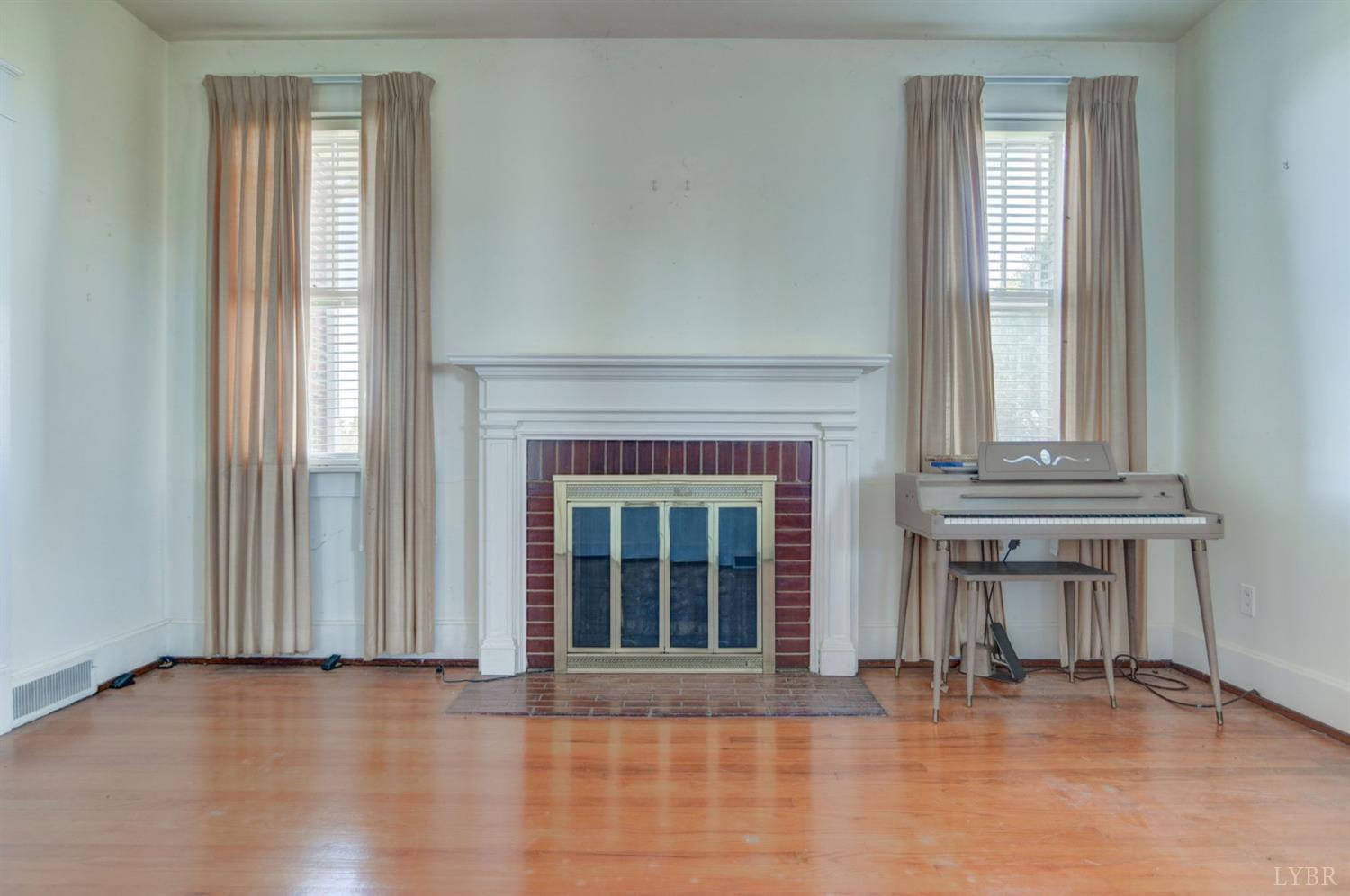 231 Epsons Road Long Island, VA 24569 - Photo 4 of 38 an empty room with fireplace and windows