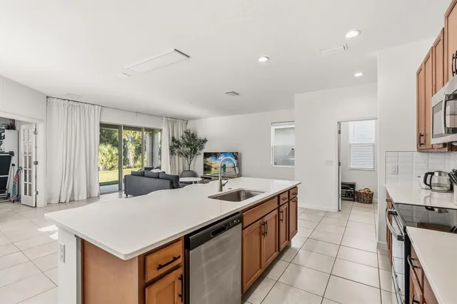 a kitchen with a sink a counter top space and stainless steel appliances