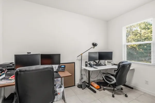 a view of a workspace with furniture and a window