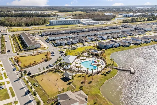 an aerial view of ocean and residential houses with outdoor space