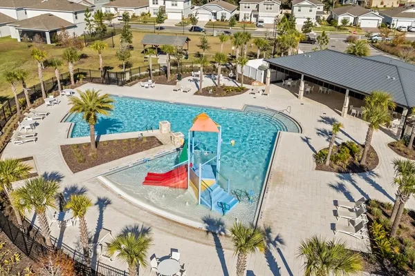 an aerial view of a house with swimming pool and outdoor seating