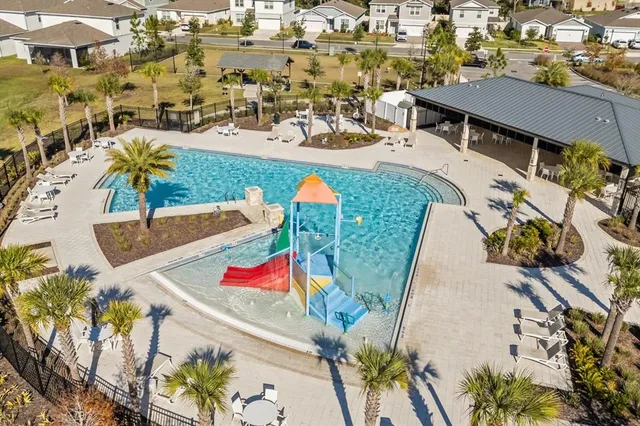 an aerial view of a house with swimming pool and outdoor seating