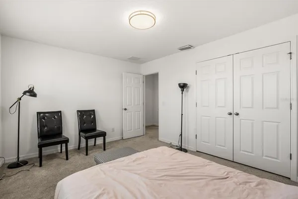 a spacious bedroom with a bed and a chair in it