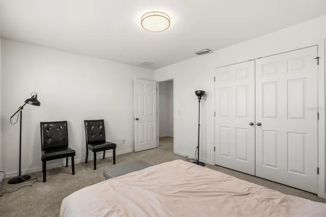 a spacious bedroom with a bed and a chair in it