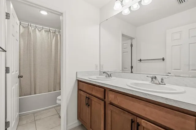 a bathroom with a double vanity sink mirror and shower