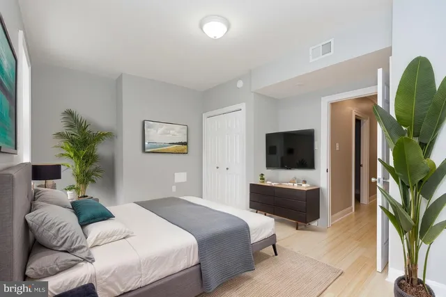 a bedroom with a balcony a bed and a flat screen tv