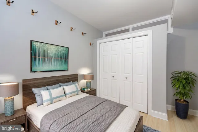a bedroom with a bed and a painting on the wall