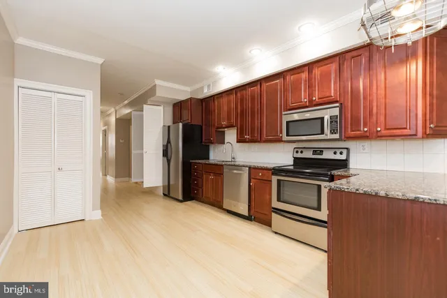 a kitchen with stainless steel appliances granite countertop a refrigerator stove top oven and sink