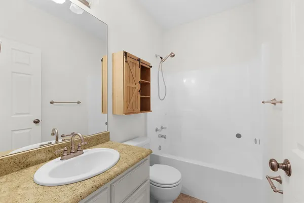 a bathroom with a granite countertop sink toilet and shower